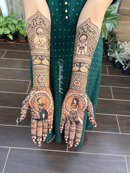 The full set of engagement mehendi, with portraits of the couple on the palms and traditional jharokha (window) designs on the arms.