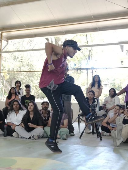 A dancer hits a dynamic move in the cypher at Spectra. Our battles are a platform for showcasing explosive energy and creative footwork.