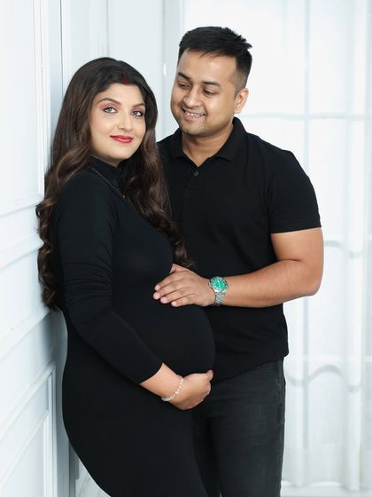 A simple and elegant portrait of a couple in matching black outfits. This classic look puts all the focus on their connection and the baby bump.