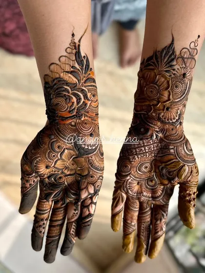 This photo showcases a complete bridal mehndi look. The designs on both hands are perfectly matched, creating a symmetrical and elegant appearance.