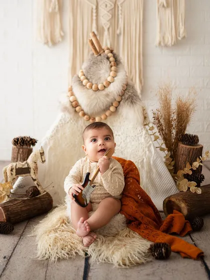 This little guy is teething on his mini guitar during his woodland-themed shoot.