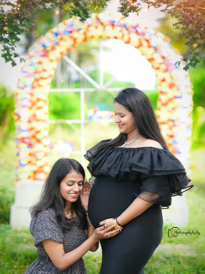A friend gently listens to the baby bump, sharing in the excitement. This outdoor shot is full of warmth and happiness.
