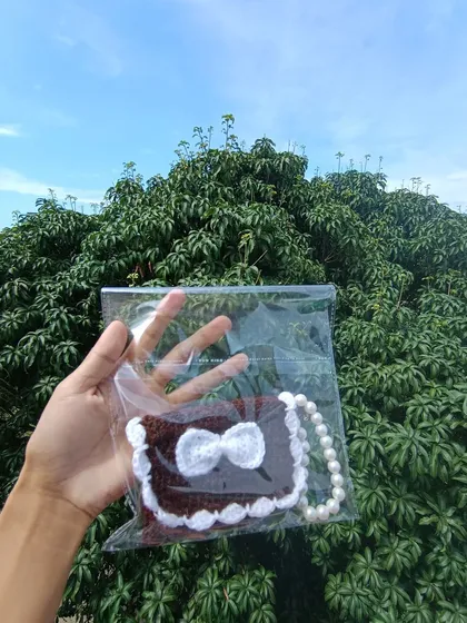A brown and white pocket purse, individually packaged and ready for sale. I ensure all items are professionally presented for my wholesale clients.