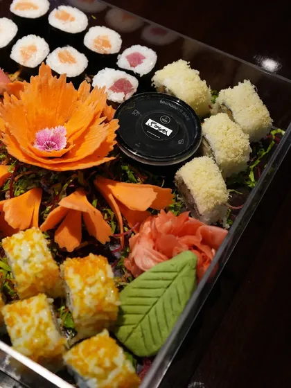 The artistry of our platters is in the details. This close-up shows our tempura crunch rolls and classic maki alongside a beautifully carved vegetable garnish, showcasing the care we put into presentation.