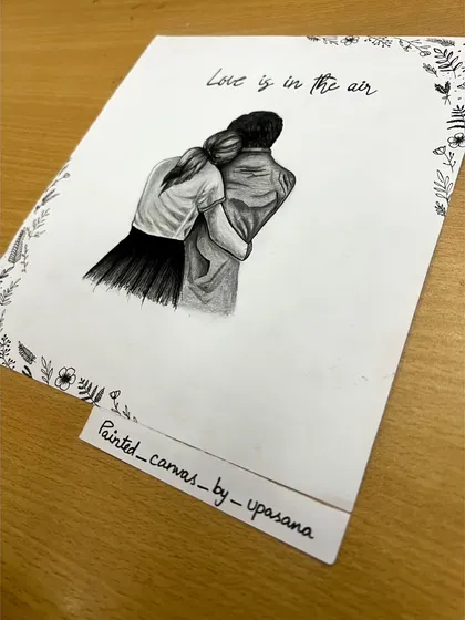 An angled shot of the custom couple sketch, showing the artwork on my desk. Each piece is hand-drawn on quality paper, ready to be framed.