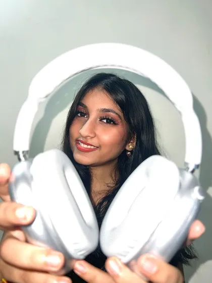 A fun, playful shot where I'm holding my headphones out to the viewer, inviting them to listen.