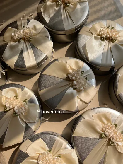 An overhead shot of the beautifully decorated silver return gift tins.