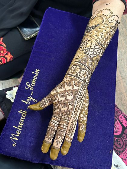 A single arm design featuring a peacock motif, a classic element in Indian mehendi.