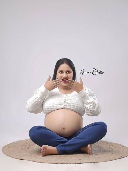 A playful and candid moment showing the mother-to-be's excitement. This casual, bare-belly shot is honest, fun, and full of personality.