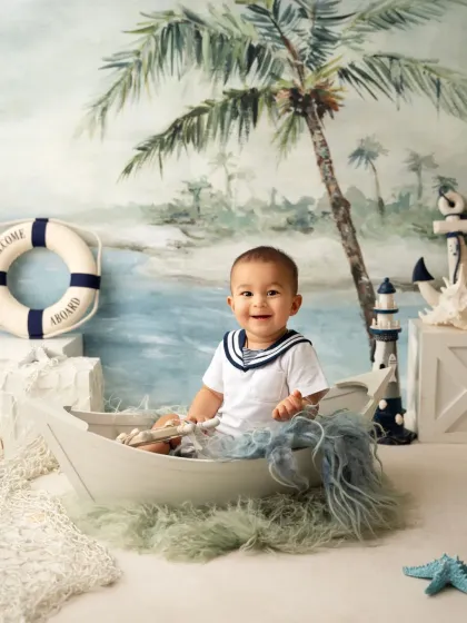 A sweet smile from a baby boy in a sailor costume. This sitter session is perfect for capturing that curious and happy stage.