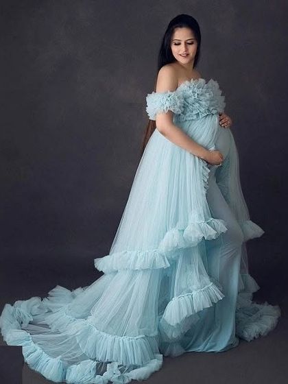 A beautiful, serene portrait of a mom-to-be in our light blue ruffled gown. The off-the-shoulder style and long train add a touch of timeless elegance.