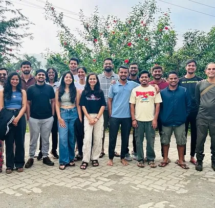 A large group of trekkers posing in front of their homestay. Our trips are a complete experience, with comfortable stays and great company.