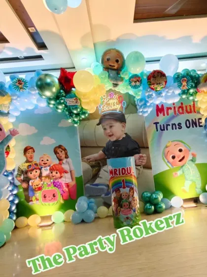 Here is a complete Cocomelon theme setup for a first birthday party at home. This package includes a custom printed backdrop with the child's photo, character cutouts, a full balloon arch, and a light-up marquee number.