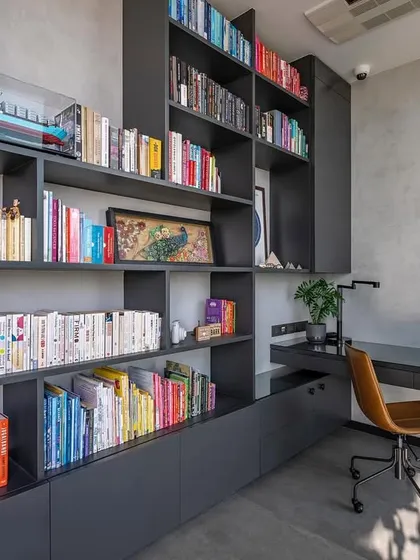 We designed this cozy nook as a home office and library. The custom-built shelves are organized to house the family's extensive book collection, with the books themselves adding pops of color to the otherwise neutral and minimalist space.