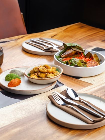 A table set with some of our most popular small plates, including the Lemon Gunpowder Idli and the Banana Leaf Bhetki. It’s a perfect spread for sharing.