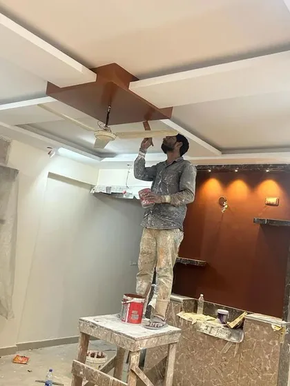 Here you can see one of my Trained Professionals applying a finishing polish to a wooden ceiling fixture, showcasing the detailed work I undertake for architectural elements.