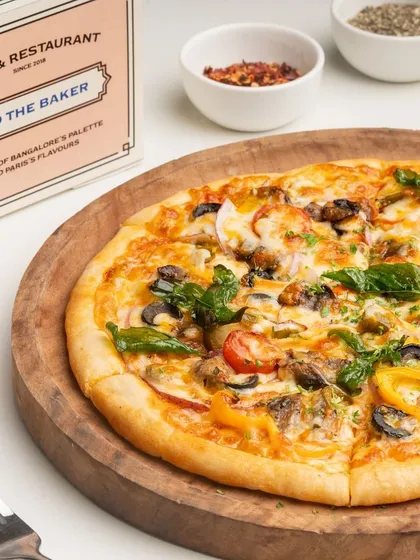 My Farmer's House Veg Pizza is loaded with fresh vegetables like bell peppers, mushrooms, onions, and olives, making it a wholesome and delicious choice.