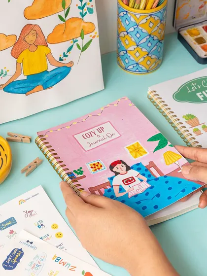 A vibrant and creative flat lay showcasing a range of stationery products. The styling uses bright colors and art supplies to appeal to artists, students, and journal enthusiasts.