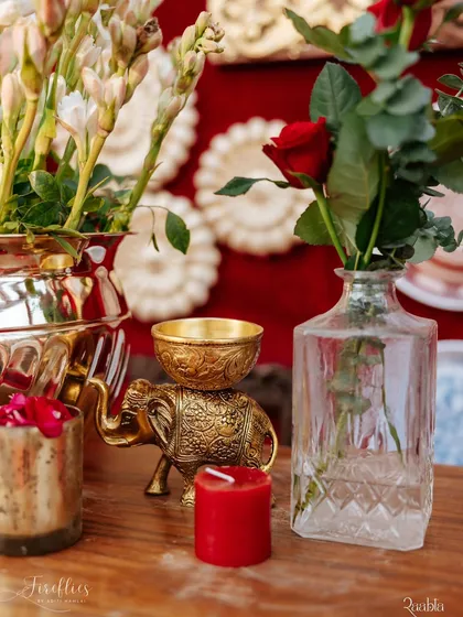 A detail shot from the 'Laal Ishq' wedding, featuring a brass elephant ornament, fresh tuberoses (rajnigandha), and a single red rose. These small arrangements added layers of texture and tradition to the decor.