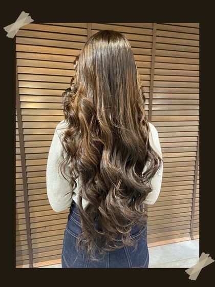 A full-length view of a gorgeous balayage, showing how the color enhances the client's long hair, making it look even more luxurious and full.