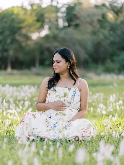 A peaceful portrait of the mother-to-be sitting cross-legged in a field of white flowers. This image has such a serene and grounded feeling, connecting her to the earth.