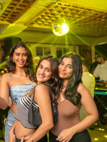 Friends taking a selfie under the disco ball at Monkey Bar. The perfect setting for a nostalgic night out.