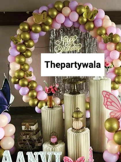 A beautiful butterfly theme with a ring-style balloon arch in pastel pink and gold. The large butterfly cutouts on balloon columns add height and dimension to the decor.