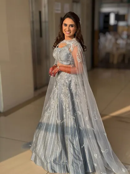 A full-length view of this stunning silver sangeet lehenga. The cape adds a touch of drama, and the makeup is kept chic and defined.