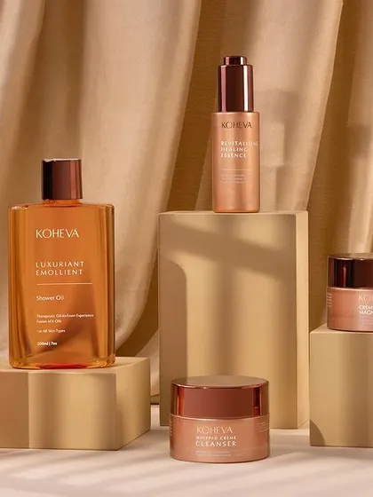 A luxurious group shot of a full skincare range. We used a draped satin cloth and neutral-colored blocks to create an elegant, high-end composition, with soft window-like shadows adding depth.