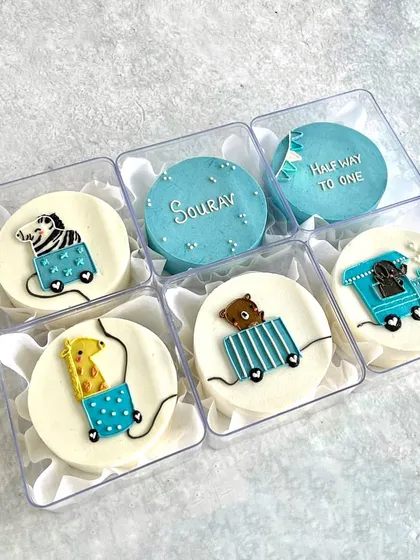 A set of mini bento cakes to celebrate a baby's six-month birthday, with a cute animal train theme.