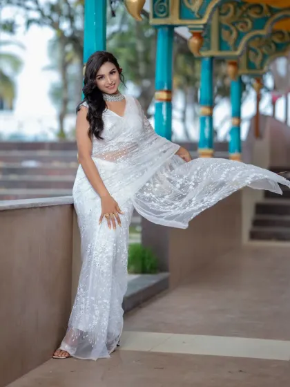 A full-length shot showing the flowy white saree. The makeup is kept light and fresh to match the ethereal vibe of the outfit.