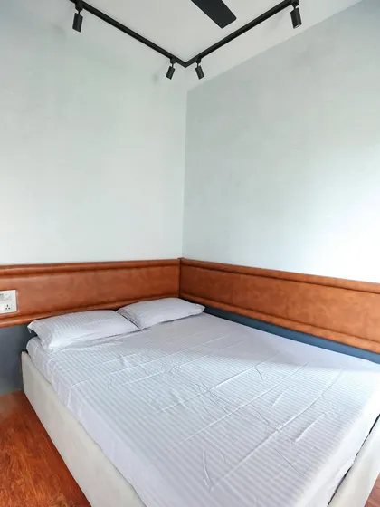 This rustic master bedroom features a leather-look upholstered headboard that wraps around the corner, creating a cozy and defined sleeping area.