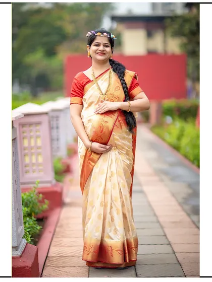 A full-length portrait of a mom-to-be in a beautiful traditional saree, looking radiant and serene.