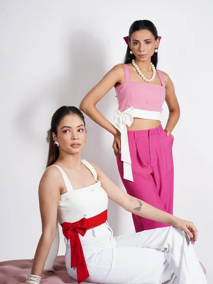 For this studio campaign, I styled two models in coordinated yet contrasting outfits. The focus was on clean lines, bold color blocking with red and pink, and statement accessories like the waist bows and pearl necklace to create a fresh, modern aesthetic.