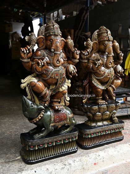 Another angle of the two large dancing Ganesha statues, showing their dynamic forms.