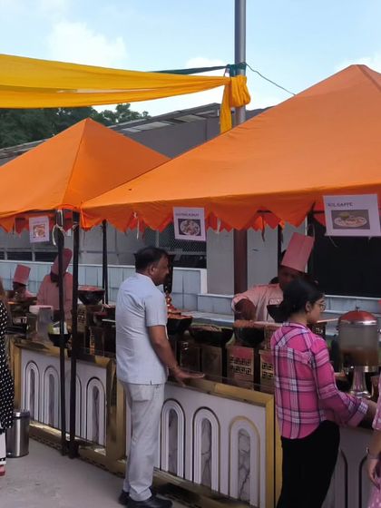Guests lining up at our food stalls during a daytime corporate or community event. Our efficient setup ensures smooth service even with a high volume of attendees.
