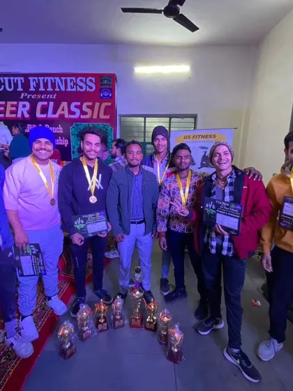 This is my team, TEAM MAHABALI, after a successful competition at the V Cut Fitness Veer Classic. We don't just train, we compete and we win. The trophies and medals are proof of our hard work.