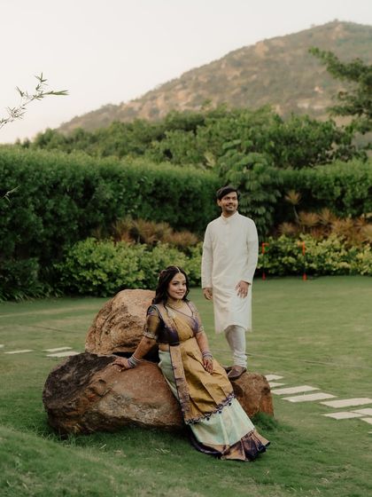 A portrait that feels both posed and natural. The couple is set against a backdrop of rolling hills, their relaxed stances creating a calm and peaceful image.