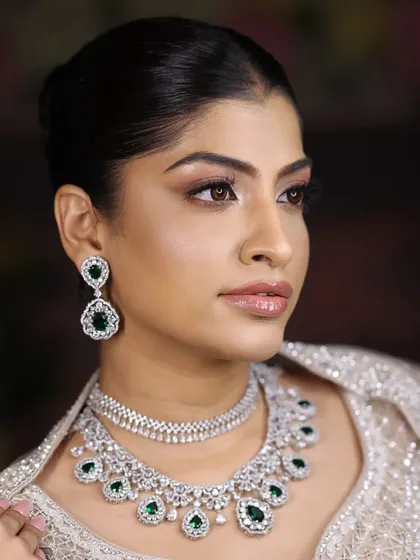 This portrait captures the sophisticated charm of the emerald and zircon layered necklace. It's a versatile piece that can be dressed up for a grand reception or worn to a chic dinner party.
