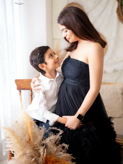 Including older siblings in a maternity shoot is a wonderful way to capture the family's excitement. This is a beautiful moment between a mother and her son.