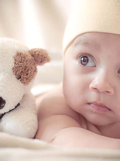 An alert newborn enjoying some tummy time with a stuffed animal friend. I capture both sleepy and awake moments to show your baby's budding personality.