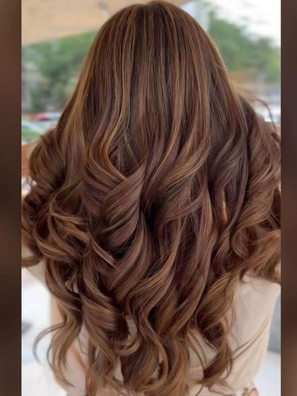 A gorgeous hazelnut balayage. The warm, nutty tones are expertly blended to create a rich, multidimensional color that looks beautiful in loose curls.