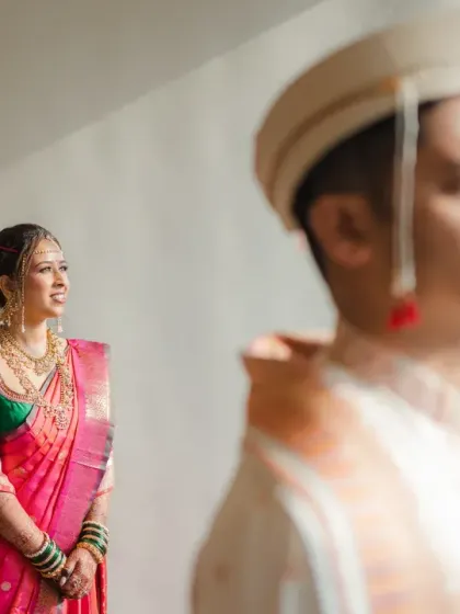 A beautiful first look portrait of the Marathi bride, with the groom in the foreground. The soft light and artistic composition create a sense of anticipation and romance.