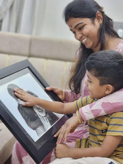 The pure, unfiltered reaction of a child seeing his family in a sketch is priceless. He gently touches the portrait, connecting with the memory I helped bring to life.