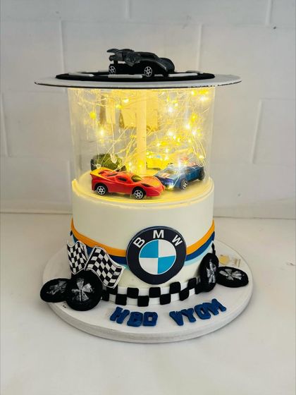 A show-stopping BMW-themed cake with a light-up clear tier showcasing toy cars.