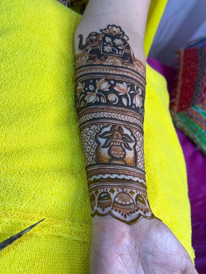 The arm section of a bridal mehndi, showing how we incorporate traditional elements like the elephant and kalash to complement the main portraits on the palm.