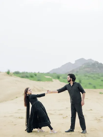 A graceful and romantic pose with the couple dancing in the soft sand of the dunes.