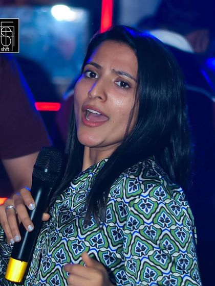 A guest singing her favorite tune during our high-energy Wednesday karaoke. The focus is always on having a good time and expressing yourself.