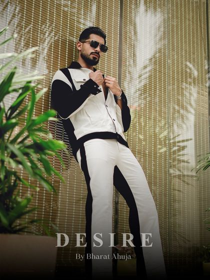 Leaning with an air of effortless cool, this shot highlights the dynamic lines of the black and white co-ord set. It's a modern look for the man who owns his style.