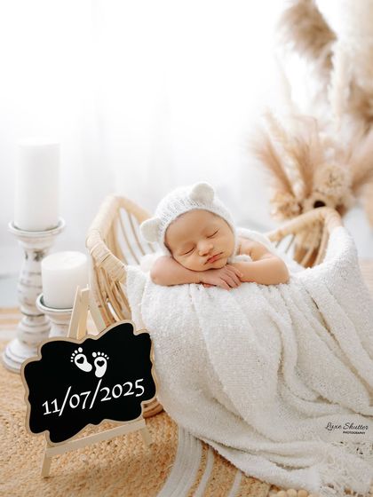 A personalized newborn announcement photo with a chalkboard sign. The baby wears an adorable bear-ear bonnet in this clean, bright, and modern setup.